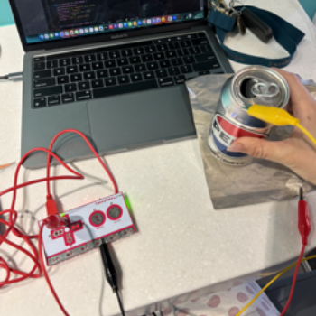 I connected the grounding wire to the pepsi can (yellow) and the red wire (the top arrow wire) to the conductive cloth.